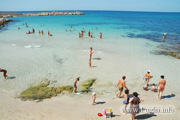 Foto del lido sabbioso a Torre Vado nel Salento in puglia. Accanto al porticciolo turistico sovrastato dalla torre Saracena.